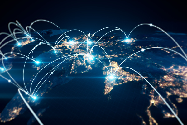 Mapa nocturno del planeta con rutas de conexión y nodos luminosos que representan redes de telecomunicaciones y conectividad internacional.