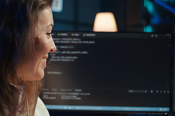 Profesional trabajando frente a monitores con herramientas de desarrollo y paneles técnicos en un entorno digital.